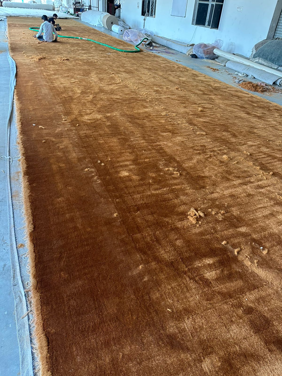 Broadloom carpet production - artisan working on large scale carpet